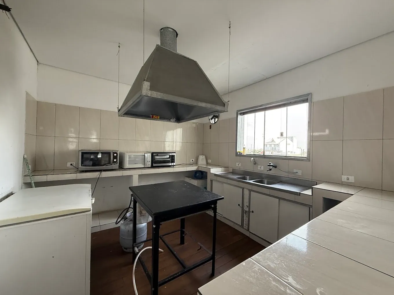 Cozinha com coifa, bancadas e micro-ondas