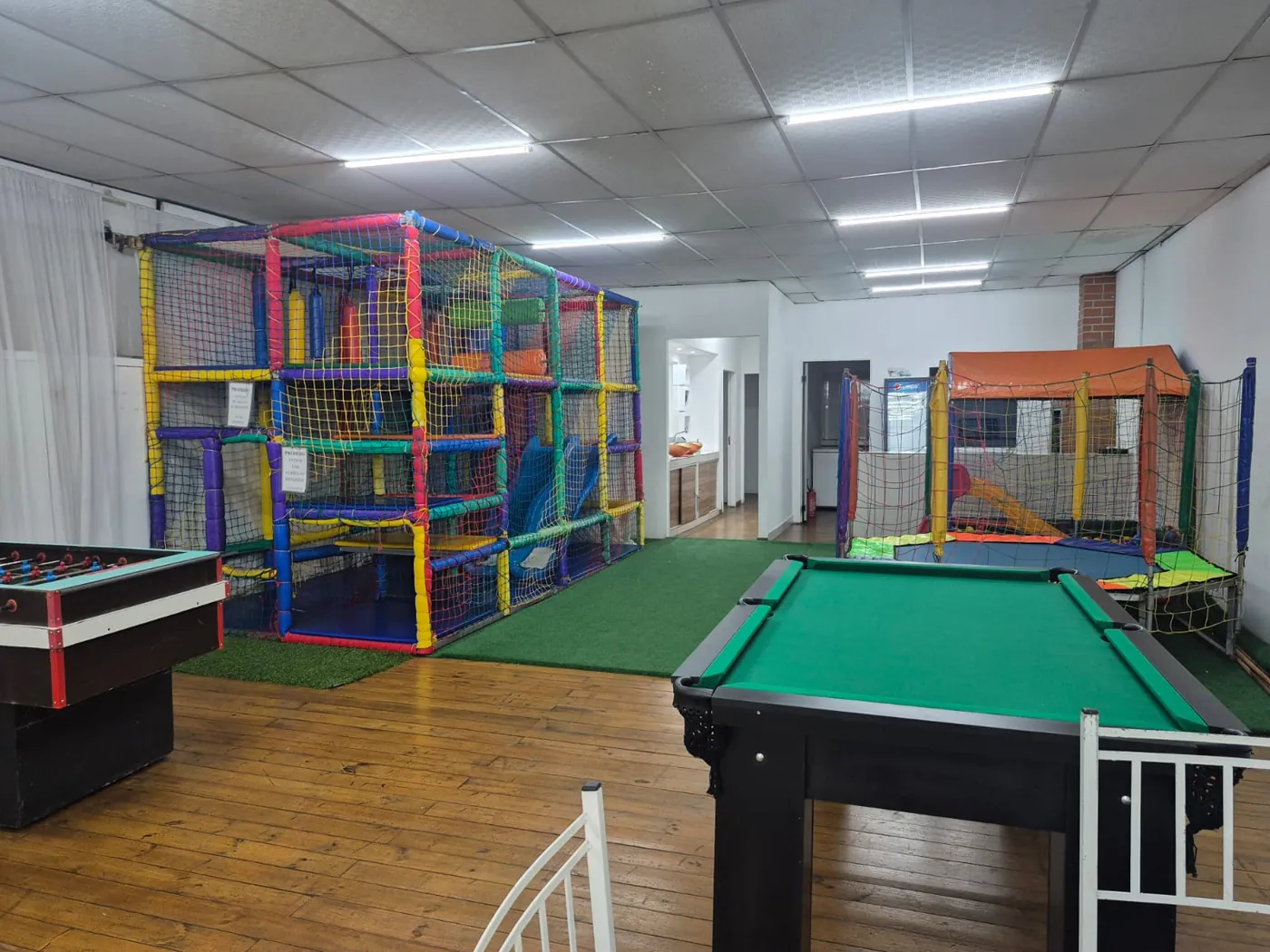 Mesa de sinuca, pebolim e playground no salão